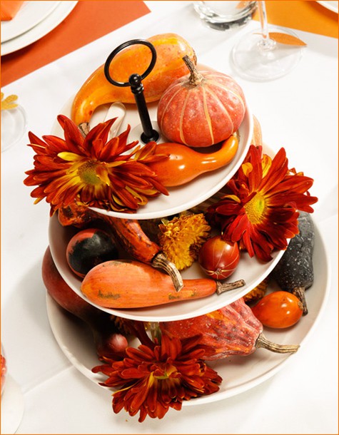 a tiered Thanksgiving centerpiece of faux gourds, pumpkisn and blooms will last really long and can be used year after year