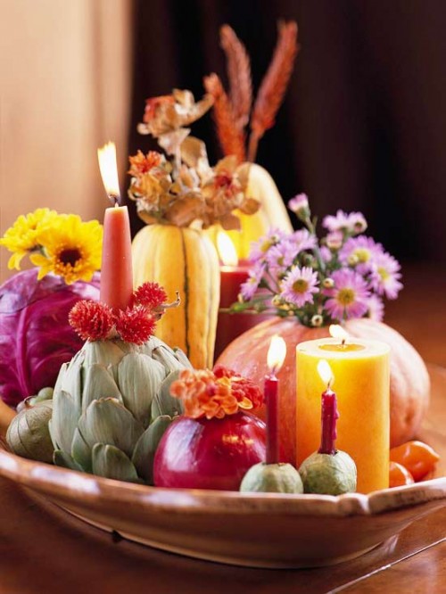 a porcelain bowl with pumpkins, cabbages, artichokes, pears, bright blooms and bold candles is a creative harvest centerpiece