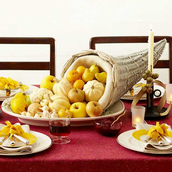 a cornucopia centerpiece with pumpkins, apples, pears, lemons and onions is a nice Thanksgiving centerpiece