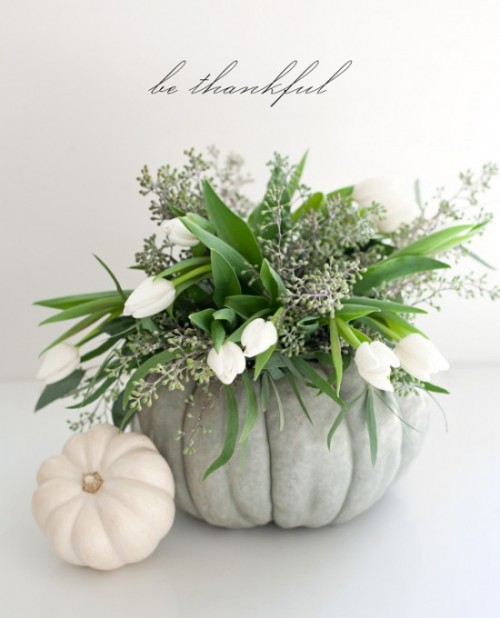 a grey heirloom pumpkin with greenery, eucalyptus and white tulips is a fresh and all-natural centerpiece for Thanksgiving
