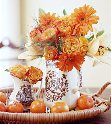 a woven tray with citrus and orange blooms in printed vases is a lovely idea for vintage Thanksgiving styling