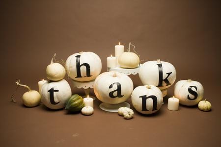 neutral candles in candleholders, white pumpkins with THANKS letters to make a cool fall centerpiece
