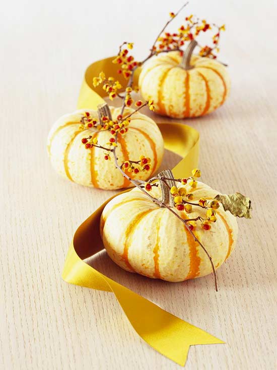 mini pumpkins and berries and a mustard ribbon is a stylish fall or Thanksgiving centerpiece