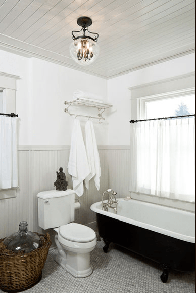 a vintage neutral bathroom with a bottle in a basket that brings a cool and interesting touch to the space
