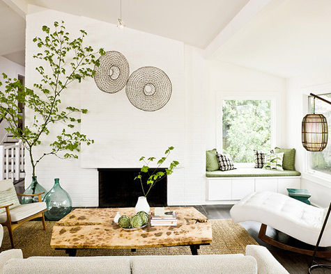 oversized green bottles with green branches by the fireplace refresh the space and make it cooler and bolder
